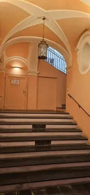 a staircase in an old building with a chandelier at Heart of Vieux Nice Beach & Saleya in Nice