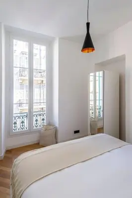 a white bedroom with a bed and a window at Elegant T2 rénové 4 Pers, Centre Nice, Climatisé in Nice