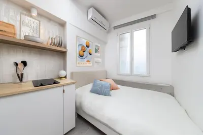 a white bedroom with a bed and a desk at Unique Old Town Designer Studio in Nice