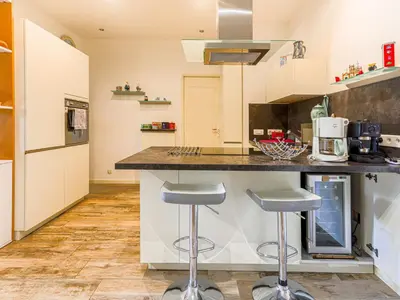 a kitchen with a counter and two stools at Apartment Terrasses de la Baie des Anges by Interhome in Nice