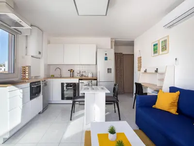 a kitchen and a living room with a blue couch at Apartment Villa Emeraude by Interhome in Cagnes-sur-Mer