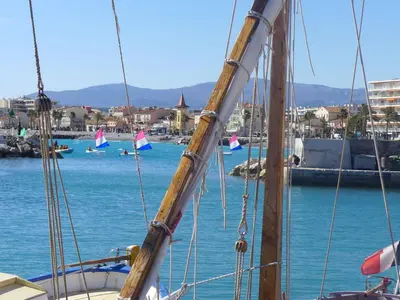 a sail boat in the water with people swimming in the water at Apartment Villa Emeraude by Interhome in Cagnes-sur-Mer