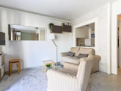 a living room with a couch and a mirror at Apartment Les Arènes de Cimiez-1 by Interhome in Nice