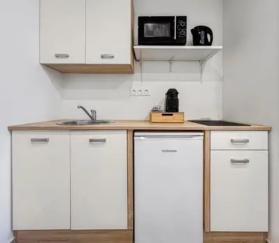 a kitchen with white cabinets and a sink and a microwave at Studio Centre Ville proche TRAM & Port, Wifi Gratuit in Nice