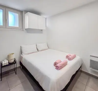 a bedroom with a bed with pink towels on it at Studio Centre Ville proche TRAM & Port, Wifi Gratuit in Nice