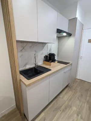 a kitchen with white cabinets and a sink at appartement carré d'or in Nice