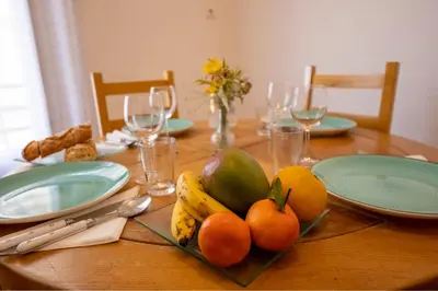 a wooden table with fruits and plates on it at * Le Provençal * cosy flat 3 min walk from the sea in Nice