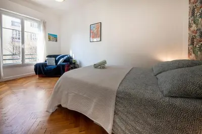 a bedroom with a bed and a chair and a window at * Le Provençal * cosy flat 3 min walk from the sea in Nice
