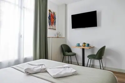 a bedroom with a bed with two chairs and a television at App-Art in Nice