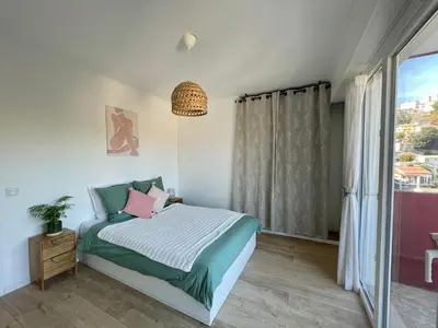 a bedroom with a bed and a window at Bright appartment with view in Cagnes-sur-Mer