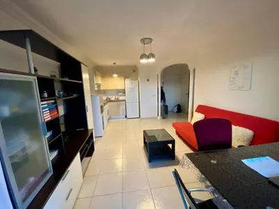 a living room with a red couch and a table at Nice Ouest St Isidore- 2P au calme in Nice