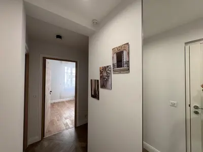 a hallway with a white wall with paintings on it at Oscar in Nice