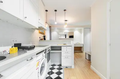 a kitchen with white cabinets and a black and white checkered floor at Lovely 1 Bdr Port Area in Nice