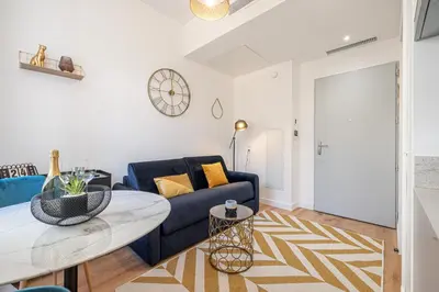 a living room with a blue couch and a table at Charming City Center Studio 104 in Nice