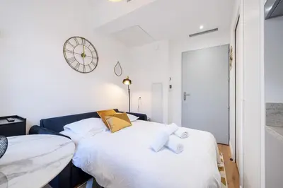 a bedroom with a bed and a clock on the wall at Charming City Center Studio 104 in Nice