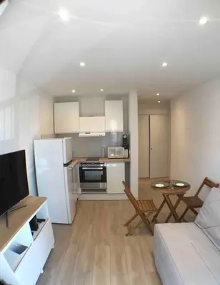 a kitchen and living room with a couch and a table at Nice bas Cimiez- Coquet F1, climatisée, Parking in Nice