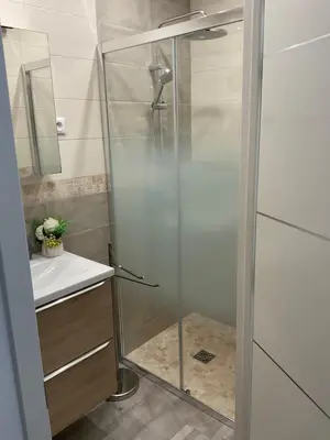 a shower with a glass door in a bathroom at Studio coin nuit terrasse parking Clim in Nice