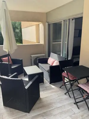 a patio with chairs and a table and an umbrella at Studio coin nuit terrasse parking Clim in Nice