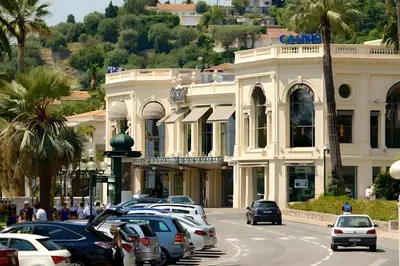 a street with cars parked in front of a building at Appartement idéalement situé proche bord de mer in Beaulieu-sur-Mer