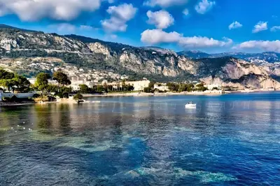 a view of a lake with a boat in the water at Appartement idéalement situé proche bord de mer in Beaulieu-sur-Mer