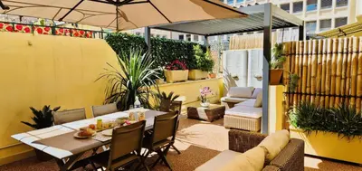 a patio with a table and chairs and an umbrella at Elegant apartment in Nice centre with grand terrace in Nice