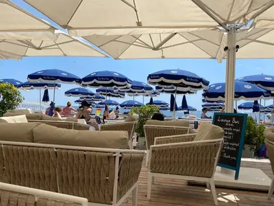 a group of chairs and umbrellas on a beach at Elegant apartment in Nice centre with grand terrace in Nice