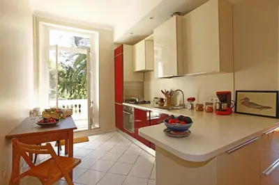 a kitchen with a counter and a table in it at PALMERAIE - Magnifique appartement d'époque avec Vue Mer 4 personnes avec terrasse Le Port Nice in Nice