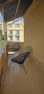 two benches and a table on a balcony at Le Virenque in Nice