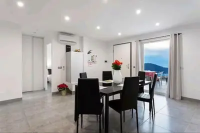 a dining room with a table and black chairs at Gite Mare e Montagne Drap 06 in Drap