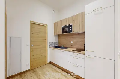 a kitchen with white cabinets and a wooden door at Suite Gold FSHH in Nice
