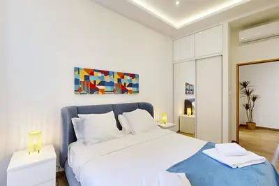 a bedroom with a large white bed with a blue blanket at Suite Gold-Stars FSHH in Nice