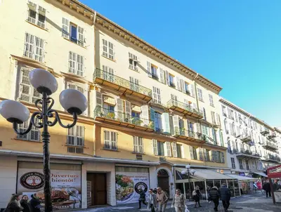 a large yellow building with people walking in front of it at Suite Stars FSHH in Nice