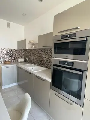 a kitchen with stainless steel appliances and a sink at Magnifique appartement avec vue sur mer in Nice