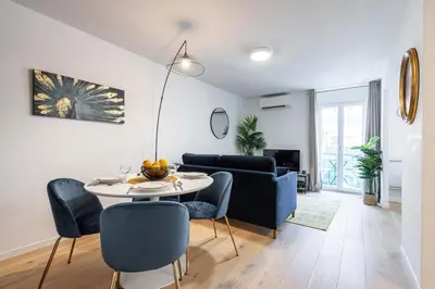 a living room with a table and blue chairs at Walesa- wifi, AC, 3 pers in Nice