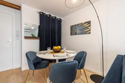 a dining room with a white table and blue chairs at Walesa- wifi, AC, 3 pers in Nice
