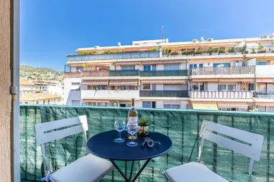 a table with two wine glasses on a balcony at Walesa- wifi, AC, 3 pers in Nice