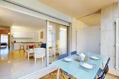 a dining room and living room with a blue table and chairs at Suite Aquarius FSHH in Nice