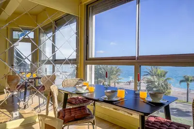 a dining room with a table and a view of the ocean at Maison Bianchi - 187 Promenade des Anglais - Sea view in Nice