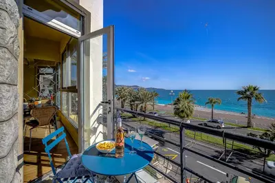 a table on a balcony with a view of the ocean at Maison Bianchi - 187 Promenade des Anglais - Sea view in Nice