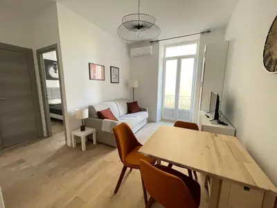 a living room with a table and a couch at COMBOUL in Nice
