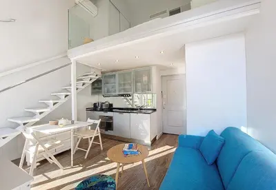 a living room with a blue couch and a kitchen at Nestor&Jeeves - ECLAT NICOIS - Central - Near beach in Nice