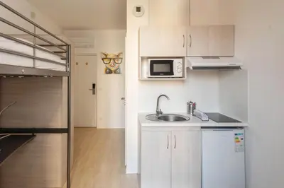 a small kitchen with a sink and a microwave at Résidence de l'Alliance in Nice