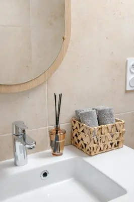 a bathroom sink with a mirror and a basket of towels at Serenity chic apartment Nice center in Nice