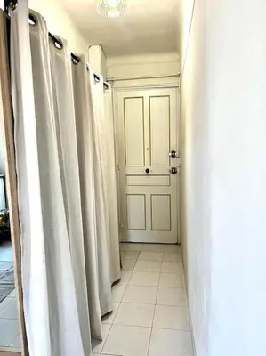 a hallway with white curtains and a white door at Studio de charme hyper centre in Nice