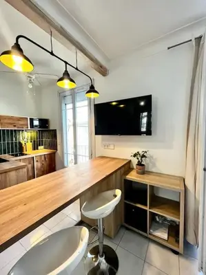 a kitchen with a table and a chair in a room at Studio de charme hyper centre in Nice