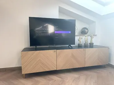a large flat screen tv on top of a wooden cabinet at Elegant mansardé-place du pin in Nice