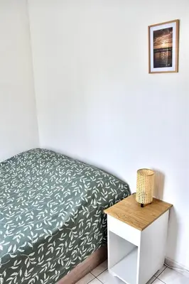 a small bedroom with a bed and a nightstand at Bel appartement au cœur de Nice (2 chambres) in Nice