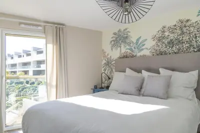 a bedroom with a large white bed and a window at SPLENDIDE APPARTEMENT NICE BLUE PEARL TOUT CONFORT VUE MER PANORAMIQUE in Nice