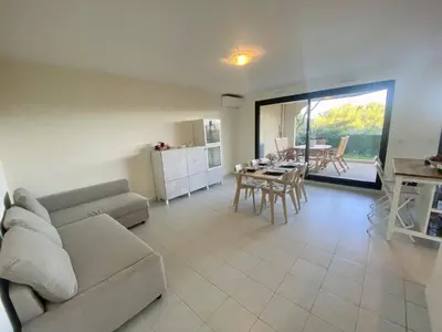 a living room with a couch and a table at Nice Ouest- 2P au Calme, Piscine, AC in Nice