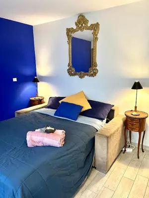 a bedroom with a bed with a mirror on the wall at SuperbeStudio in Nice - 450m of the sea- garden view in Nice